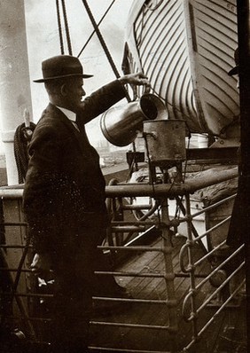 Ship fumigation using hydrogen cyanide: an operator pouring cyanide solution into a funnel. Photograph by P. G. Stock, 1900/1920.