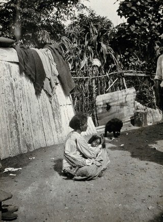 Durban, Natal, South Africa: an Indian mother de-louses the hair of a child held on her lap. Photograph, ca. 1910.