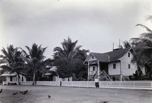 view Gospel Church village, Chiengmai Leper Asylum, Thailand: the asylum overseer's large house next to smaller wooden houses. Photograph, 1921.