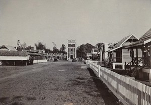 view Chiengmai Leper Asylum, Thailand: a water tower and cottages. Photograph, ca. 1921.