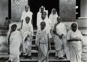 view The Albert Victor asylum for lepers, Gohea, Calcutta, India: female patients in white saris on the steps of the female block. Photograph, 1900/1920.