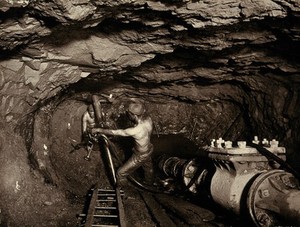 view Tincroft tin mine, near Camborne, Cornwall: two miners at work in a mine shaft. Photograph by J. C. Burrow, 1890/1910.