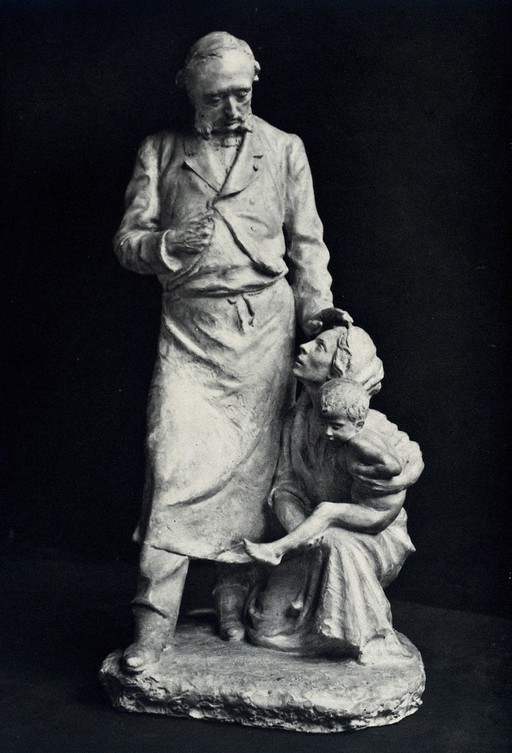 Léopold Ollier, the French orthopaedic surgeon, with a woman holding a child kneeling at his feet. Photograph, 1900/1920, of a sculpture by Destol(?), 1900/1920 (?).