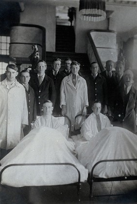 First World War wounded soldiers (naval?): group portrait: two lying in hospital beds; the remaining standing. Photograph, 1914/1918.