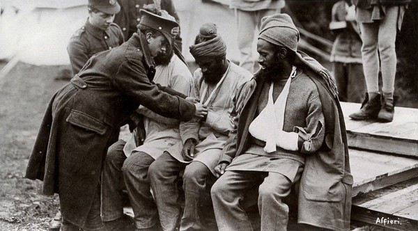 World War One: Indian soldiers with bandaged hands are cared for by British military medics. Photograph by Alfieri, 1914/1918.