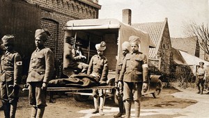 view World War One: Zelobes, France: Indian soldiers taking a patient on a stretcher from an ambulance to the dressing station. Photograph, 1915.