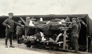 view World War One: Pushvillers, France: wounded soldiers on a trolley being taken from the Casualty Clearing Station to an ambulance train. Photograph, 1916.