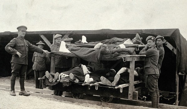 World War One: Pushvillers, France: wounded soldiers on a trolley being taken from the Casualty Clearing Station to an ambulance train. Photograph, 1916.