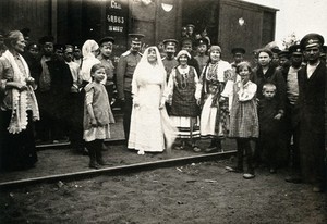 view World War One: Russia: Russian travellers in traditional dress next to a military train. Photograph, 1914/1918.