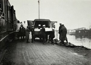 view World War One: a stretcher being loaded onto a train from an ambulance by naval medics. Photograph, 1914/1918.