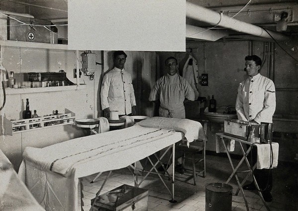 World War One: the H.M.S. Barham: operating theatre with three medics. Photograph, 1914/1918.