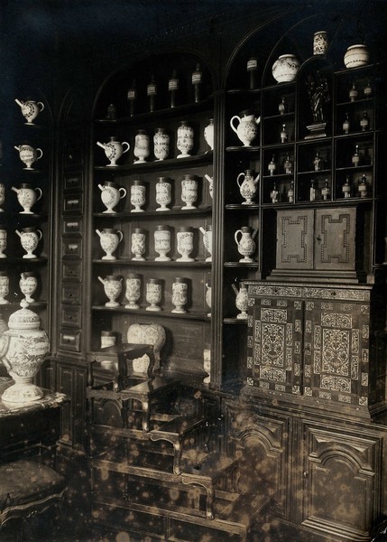 The old pharmacy of the hôpital Saint-Denis, France: ornate shelving with decorative china pharmacy jars and glass bottles. Photograph, 1890/1910.