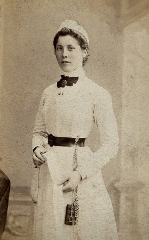 view A nurse poses in uniform in a photographic studio. Photograph, 1860/1880.