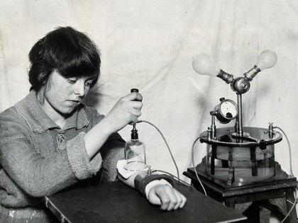 A rheumatism patient uses an electrical machine called the Galvanoset to administer drugs. Photograph, ca. 1925.