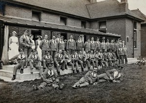 view Nottingham: soldiers in World War I, some of them wounded, standing on a verandah used for open-air treatment. Photograph, 1917.