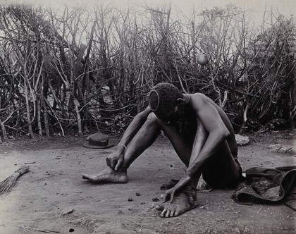 Zimbabwe: a fortune-teller 'reading' some bones. Photograph, ca. 1905.