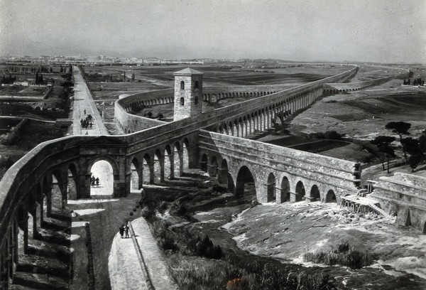 Roman aqueducts in Via Latina, to the southeast of Rome: view of the crossing of two aqueducts during ancient Roman times, with the city of Rome seen in the distance. Photograph, ca. 1936, of a painting by M. Zeno Diemer, ca. 1910/1935.