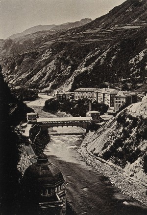 view Tarasp, Lower Engadin Valley, Switzerland: view of the En river, the covered bridge, mountains and baths of the spa town. Photograph, 1880/1920?.