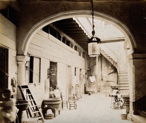 view Tenement building, Cuba: an interior view of the entrance courtyard, with stairs to upper floors. Photograph, 1902.