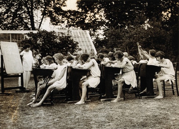 A class of schoolgirls having lessons in the open air, during hot weather. Photograph, 1925/1935?.