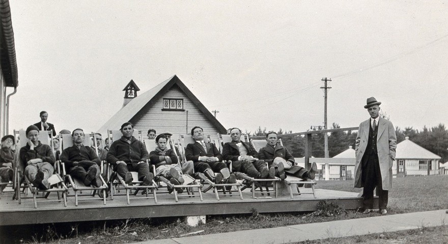 Mont Alto Sanatorium for tuberculosis, Pennsylvania: male patients are shown sitting in deckchairs in the open air, during 'rest hour'. Photograph, 1920/1940?.