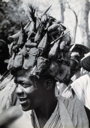 view Africa: a man wearing a head-dress (made of animal skins?). Photograph (by Kurt Lubinski?), 1940/1960.