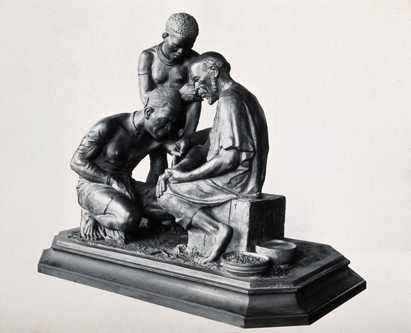 Inoculation in Africa: an African doctor inoculating one man while another watches. Photograph, 1930/1960, of a sculpture, 1913/1932 (?).