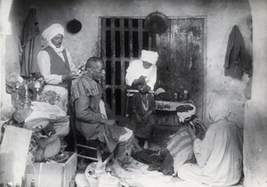 view Sudan: barbering, tooth-drawing and cupping being practised. Photograph, ca. 1920.