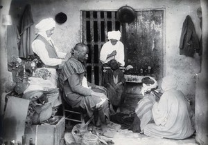 view Sudan: barbering, tooth-drawing and cupping being practised. Photograph, ca. 1920.