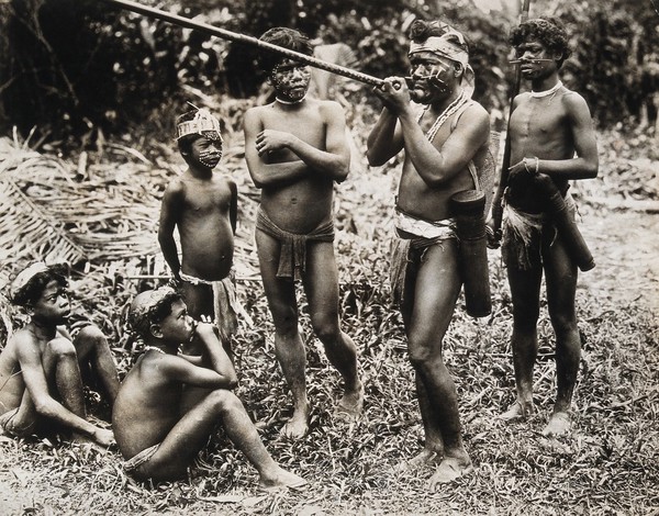 Borneo: a Dyak man demonstrating the blowpipe. Photograph, 19--.