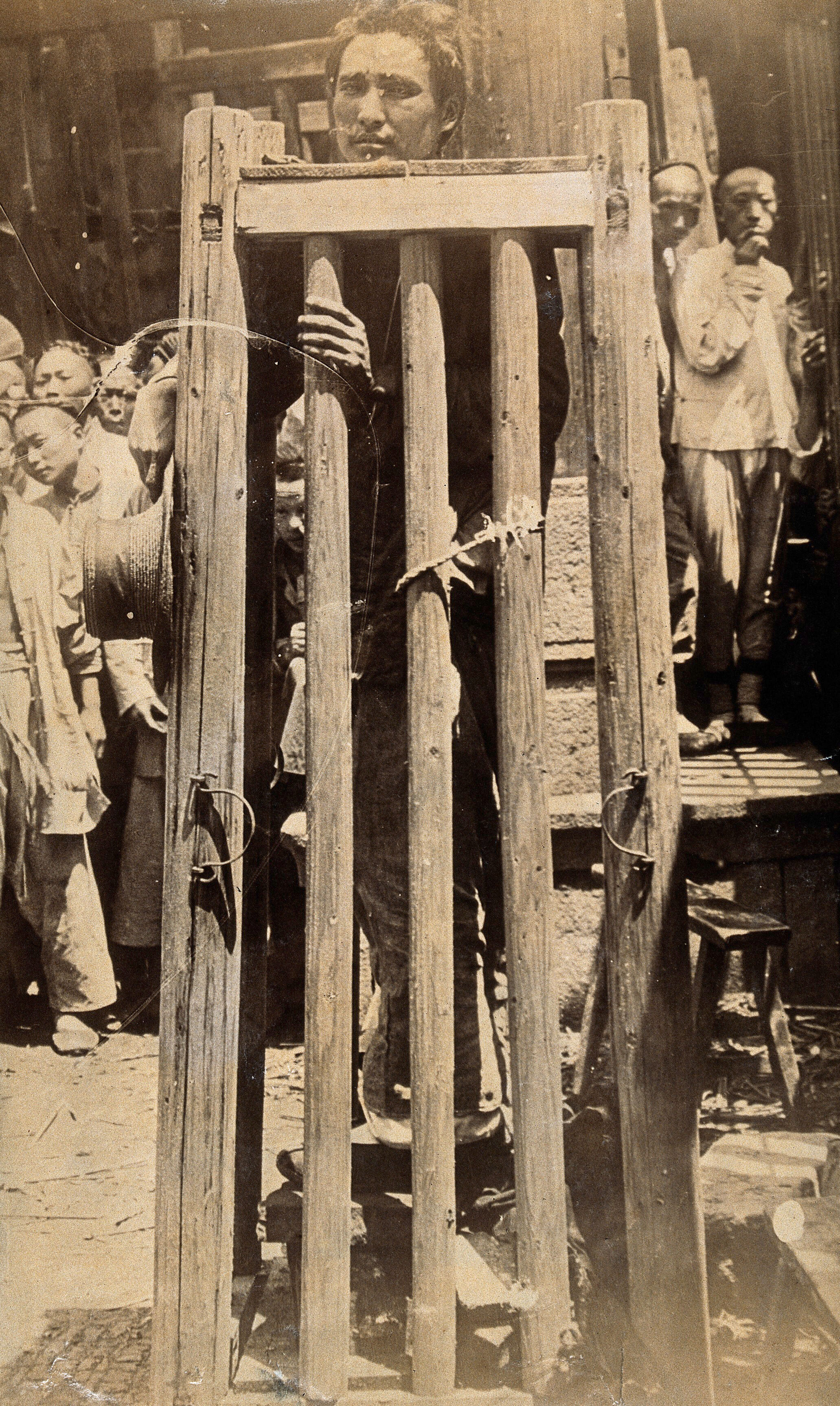 China a man standing in a locked cage as a method of slow torture or