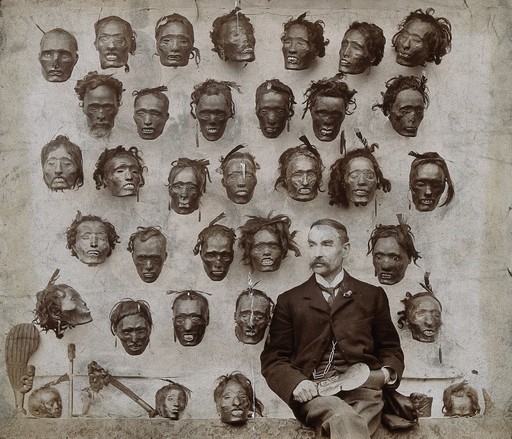 Horatio Robley, seated with his collection of severed heads
