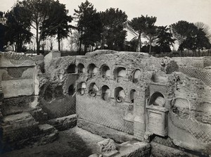 view Ostia, Rome: columbaria for holding urns containing the ashes of the dead. Photograph by Fratelli Alinari, 192-.