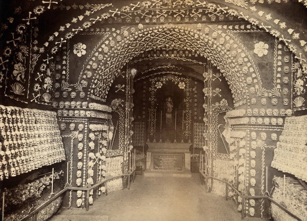 Skulls and bones of friars, looking towards the altar of a chapel. Photograph.