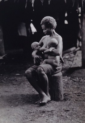 Africa: a woman breastfeeding two babies. Photograph, ca. 1940 (?).