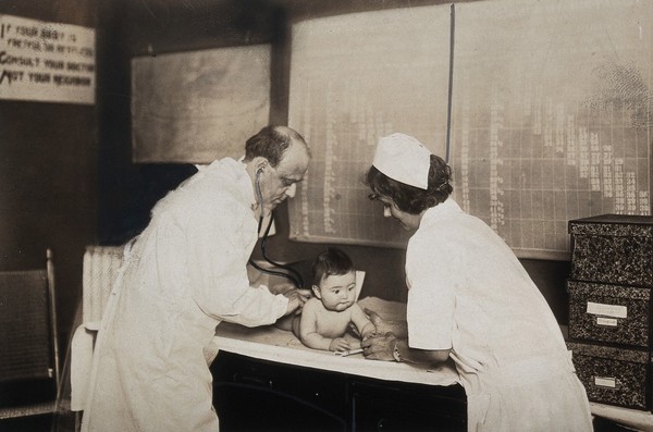 Pennsylvania, U.S.A: a State baby clinic: a baby is examined by a nurse and a doctor with a stethoscope. Photograph, ca. 1925.