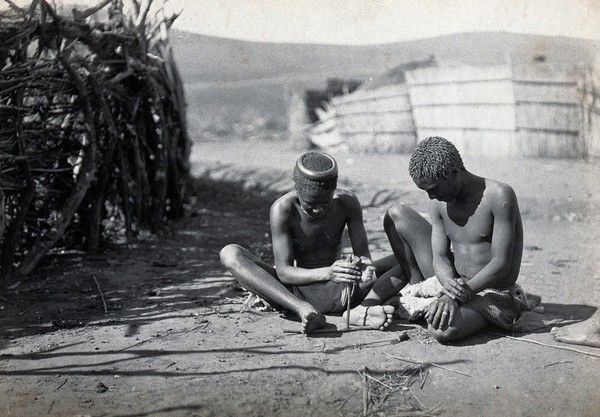 Swaziland: two seated men, one at work making files. Photograph, 1900/1920.
