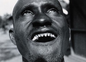 view Uganda: a Lango man with pointed, filed incisors. Photograph (by Cecil John Hackett ?), ca. 1937.