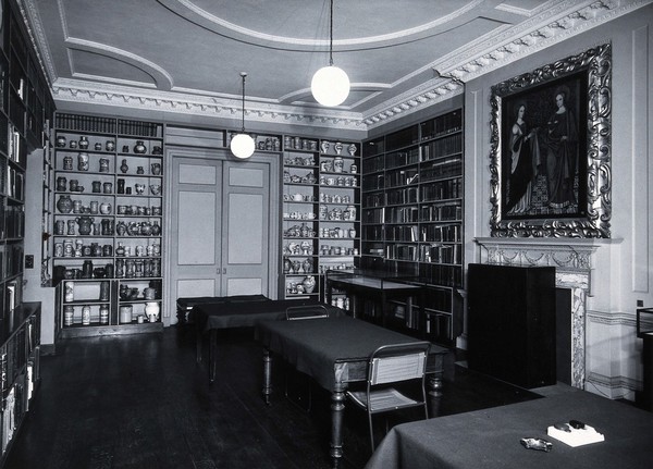 The Wellcome Historical Medical Museum, 28 Portman Square, London: the Library with shelves of medical ceramics. Photograph, n.d. [c. 1954].