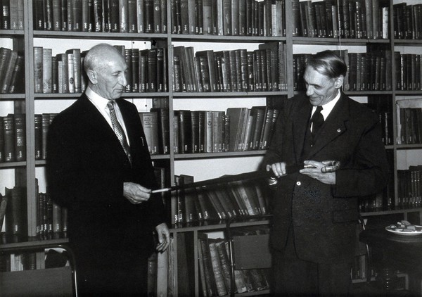 The Wellcome Historical Medical Museum, 28 Portman Square, London: the Director presenting an umbrella to A. D. Lacaille, the museum's archaeologist, on his retirement in 1959. Photograph.