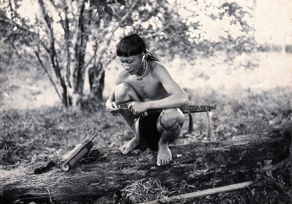 Sarawak: a Kenyah worker making darts for his blowpipe. Photograph.