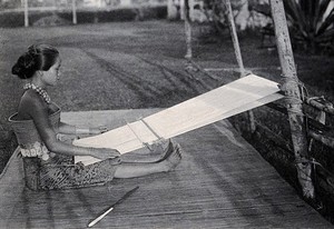 view Sarawak: a girl weaving cotton on a loom. Photograph.