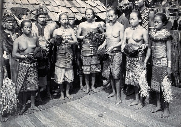 Sarawak: Sea Dayak men at a head feast. Photograph.