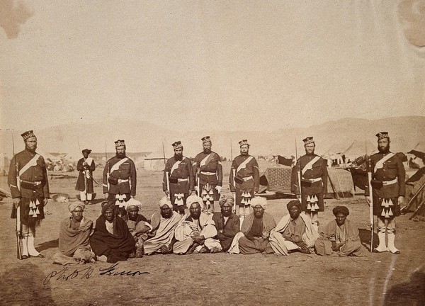 Scottish (?) soldiers with Indian men at a military encampment (during the Second China War?). Photograph, ca. 1860.