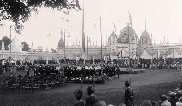 Calcutta, India: King George V and Queen Mary (then the Prince and Princess of Wales), (seated in the background), with musicians and spectators, watching entertainment given in their honour at the pandal (function hall). Photograph, 1906.