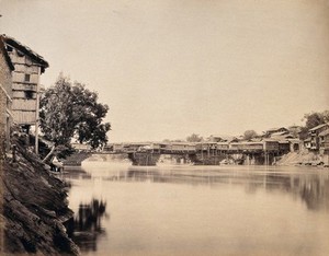 view Srinagar, Kashmir: buildings on a bridge over water. Photograph by Samuel Bourne.