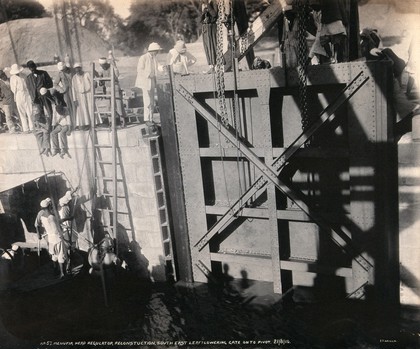 Menufia Canal, Egypt: reconstruction work to the first Aswan Dam: men at work lowering a flood gate. Photograph by F. Fiorillo, 1910.