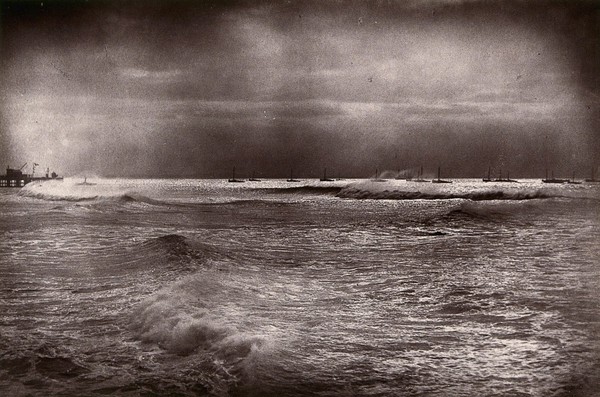 Algoa Bay, South Africa: a bay with pier and boats in a gale. Woodburytype, 1888, after a photograph by Robert Harris.