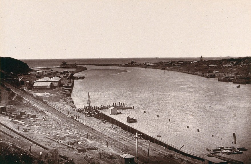 East London, South Africa: a jetty and buildings near the mouth of the Buffalo River. Woodburytype, 1888, after a photograph by Robert Harris.