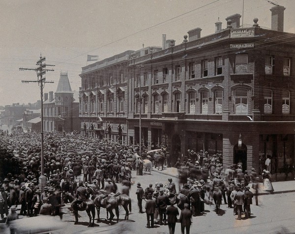 South Africa: a crowd of people gathered outside The Goldfields offices in Johannesburg. 1896.